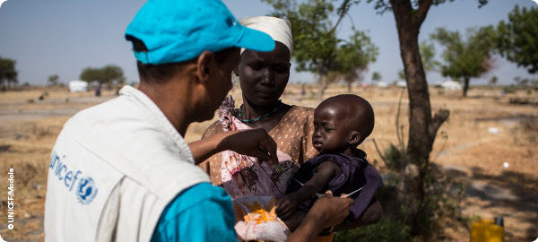 A mother and child with a UNICEF worker