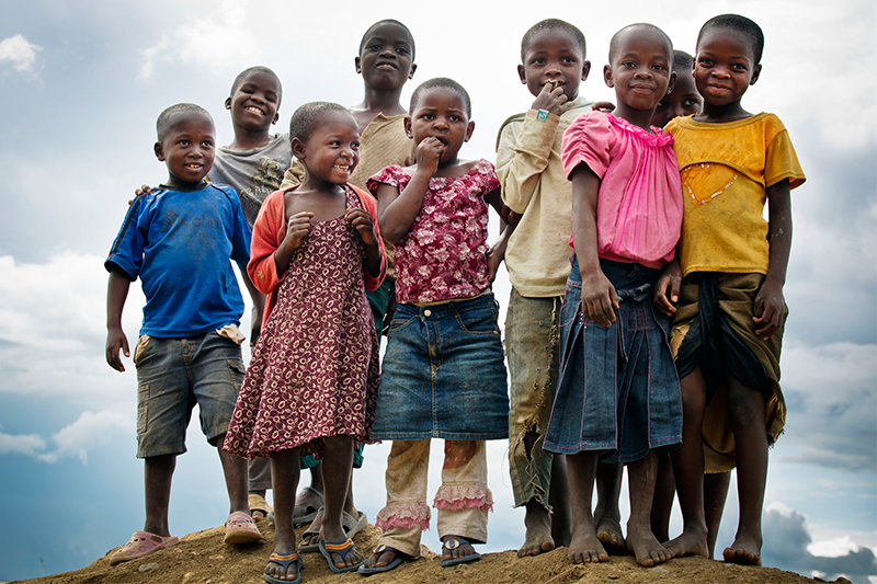 A group of smiling children standing on a hill
