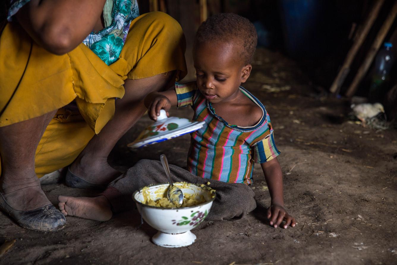 In drought-affected Ethiopia, two-year-old Habib covers a bowl of porridge.