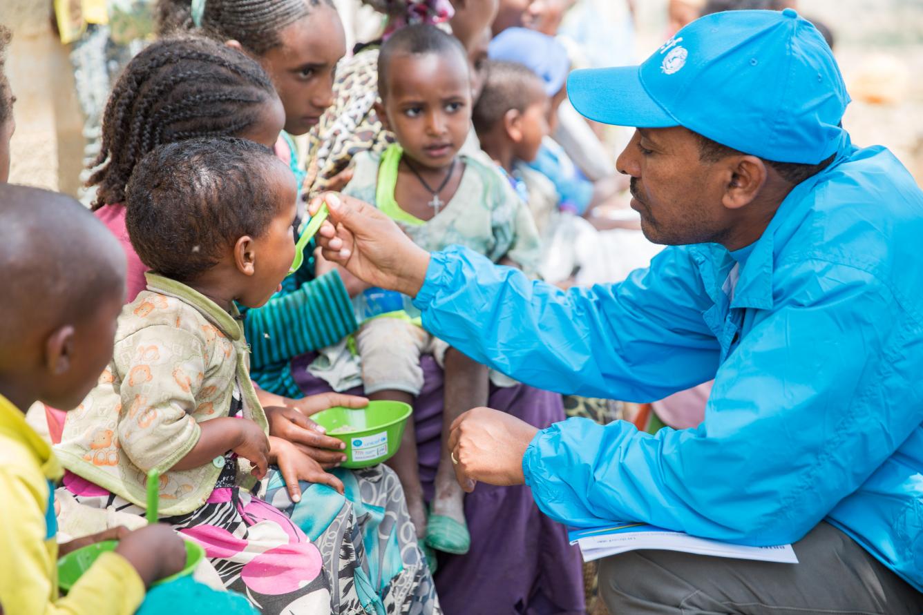 A health specialist at UNICEF Ethiopia feeds Bertukan a nutritious porridge at the Kihen Health Post.
