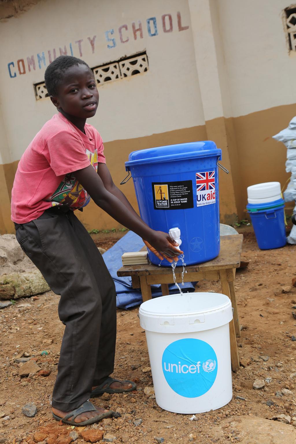 A child washes his hands at a temporary displacement centre.