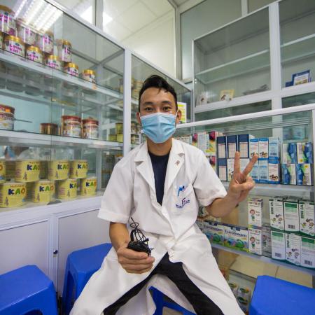 A health worker gives the 'V for Vaccinated' sign at a hospital in Vietnam.