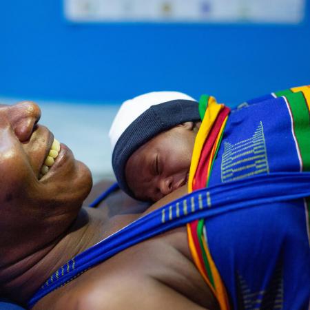 A mother practices kangaroo care with her newborn baby at a hospital.