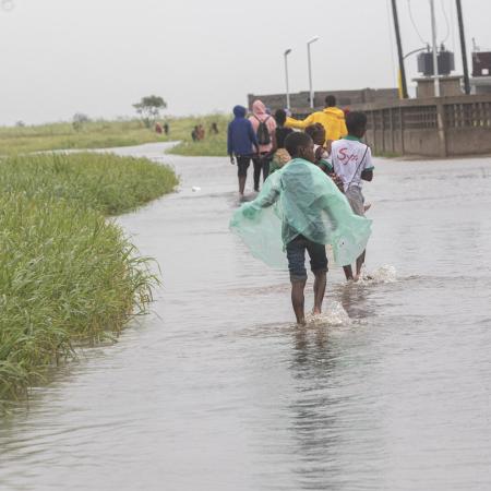 March 13, 2023. A group of children walks through a flooded street after Cyclone Freddy passes through Quelimane on March 11.