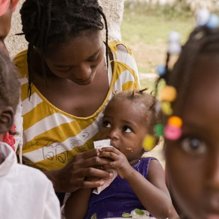 Child eating peanut plan at a health center for nutrition. Mare Briole, departement South-East, Haiti, September 2019.