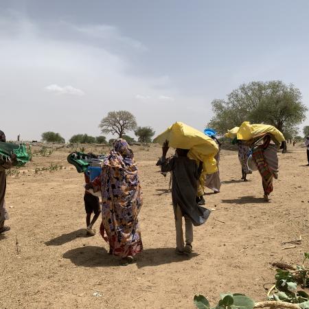 On 28 April 2023, as they cross into Koufroun, a Chadian village near the Sudanese border, refugees from Sudan carry their personal belongings.