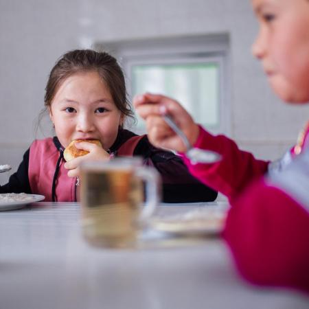 A girl eats a healthy school lunch.