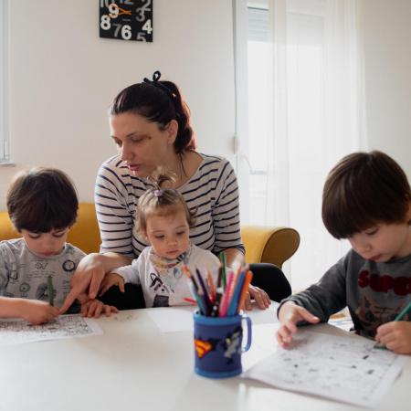 A mother in Macedonia helps her children study at home.