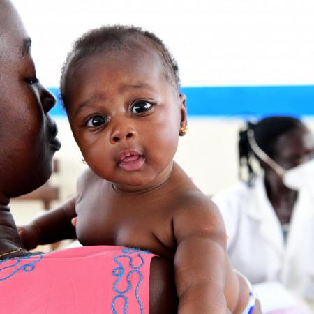 A mother holds her baby at a mobile clinic.