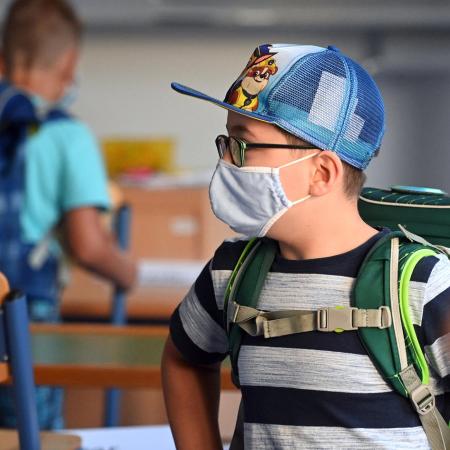 A student with a face mask stands in a classroom at the Petri primary school in Dortmund, western Germany.