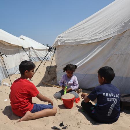 Children play in front of their tent in the UK-FCDO supported camp in Rafah, southern the Gaza Strip.