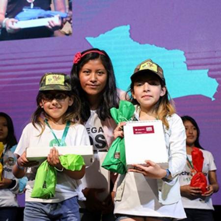 Girls receive awards at a tech event in Bolivia.