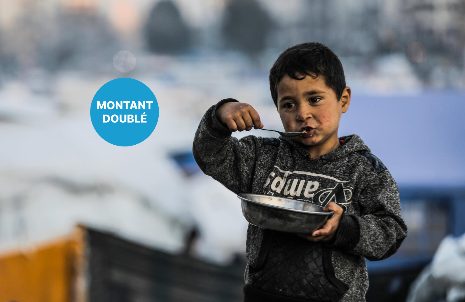 Un jeune garçon de la ville de Gaza mange son repas dans un bol en métal.