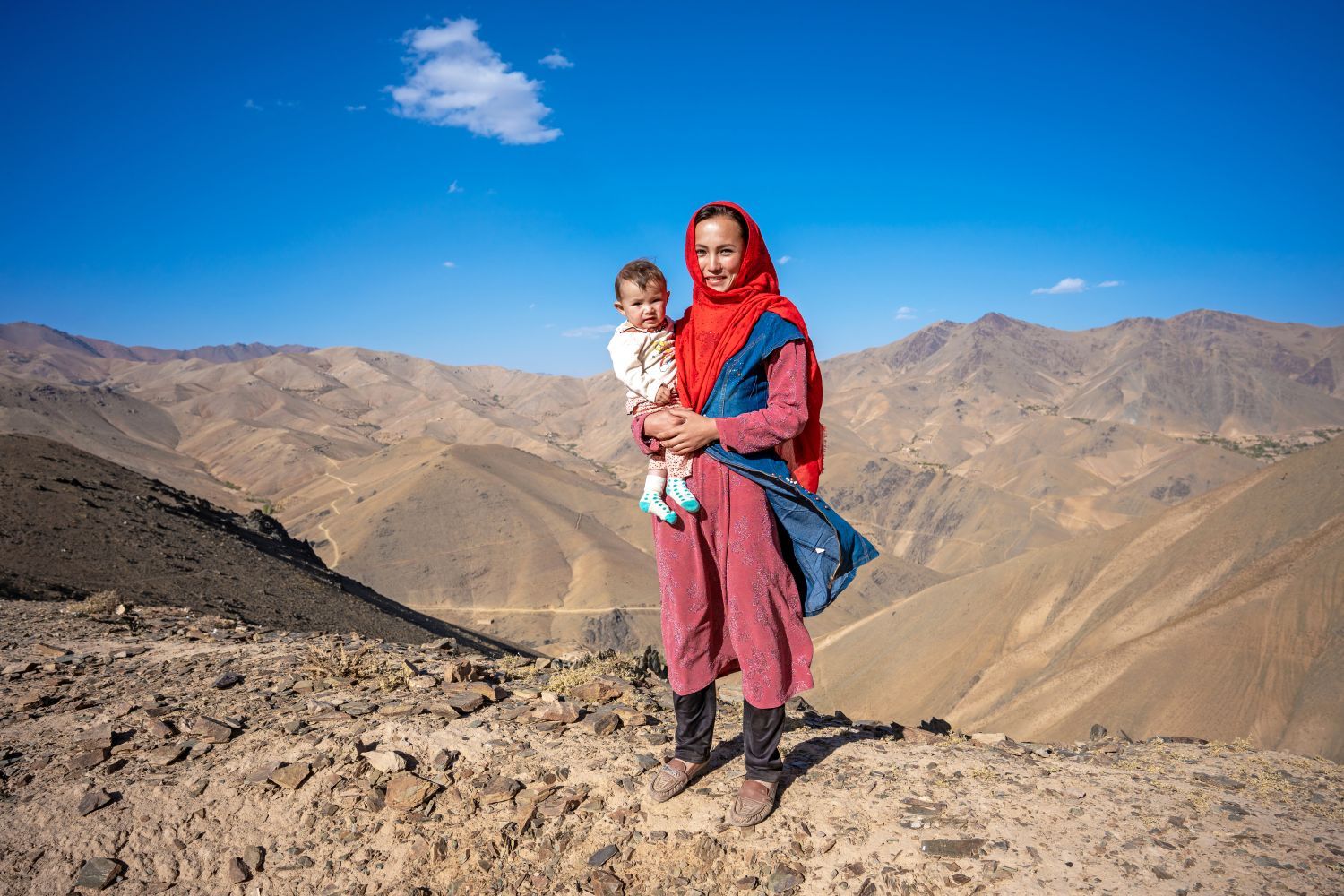 A mother smiles as she holds her child.