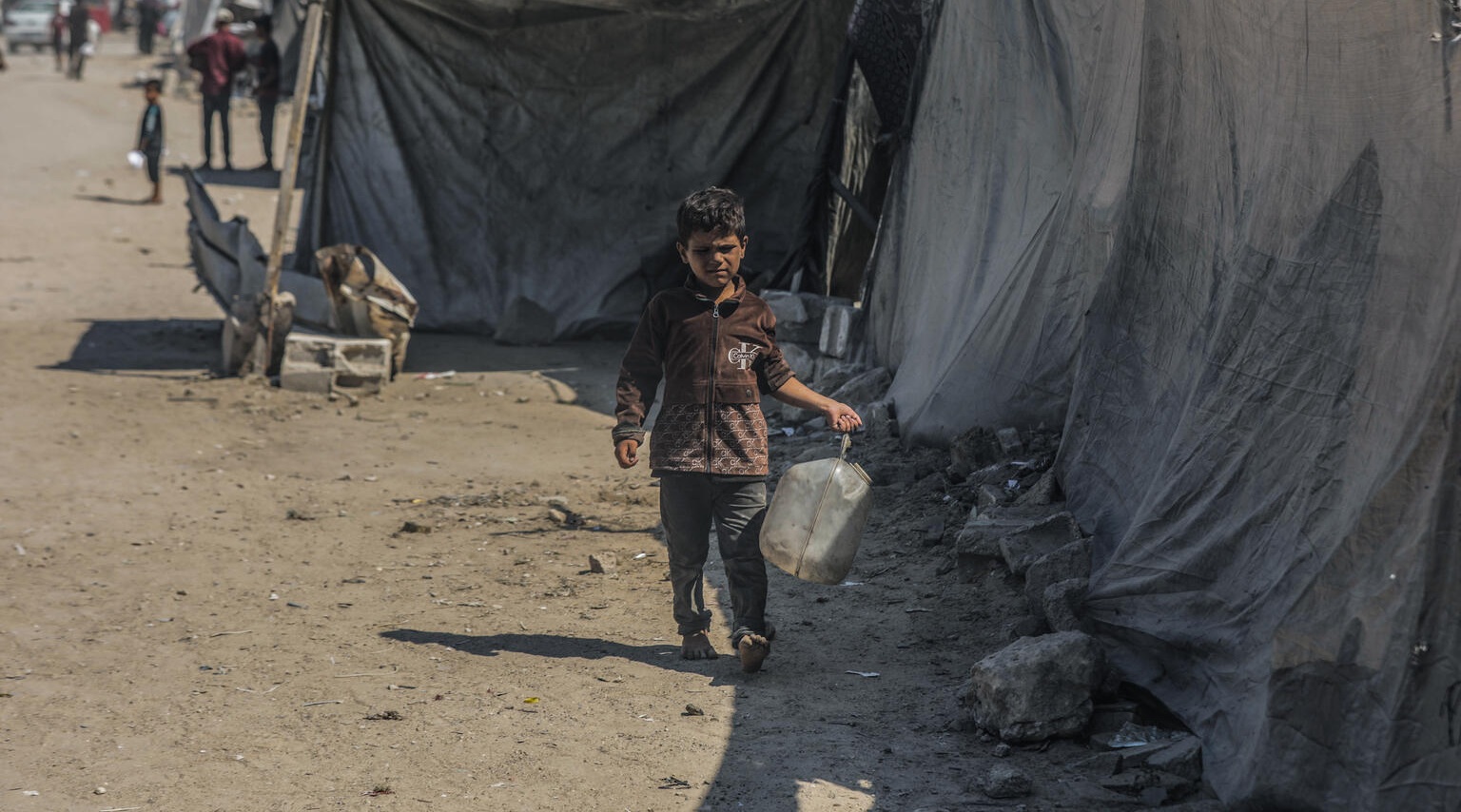 A boy carries a jerrycan of water in Gaza.
