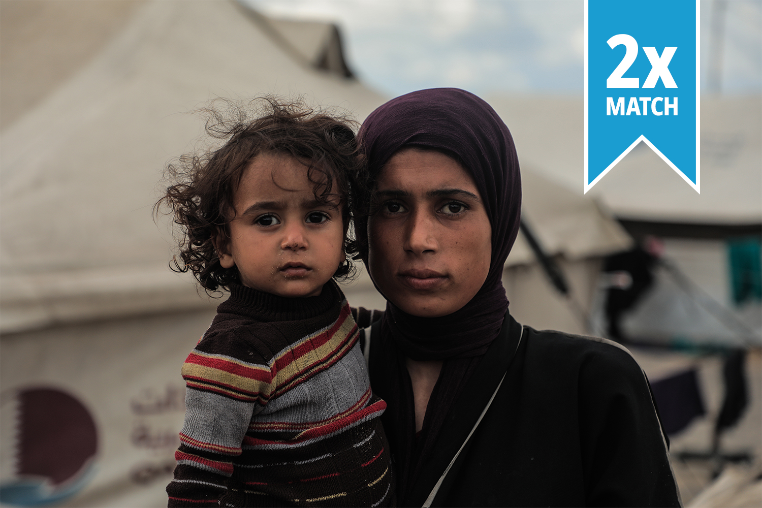 In Gaza city, a mother holds her daughter close as she looks at the camera.