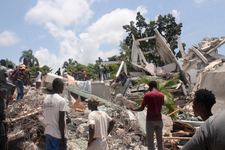 People search through the rubble of what used to be the Manguier Hotel after the earthquake hit on August 14, 2021 in Les Cayes, southwest Haiti. Rescue workers scrambled to find survivors after a powerful 7.2-magnitude earthquake struck Haiti early Saturday, killing at least 304 and toppling buildings in the disaster-plagued Caribbean nation still recovering from a devastating 2010 quake. The epicenter of the shaking, which rattled homes and sent terrified locals scrambling for safety, was about 100 miles (160 kilometers) by road west of the center of the densely populated capital Port-au-Prince.