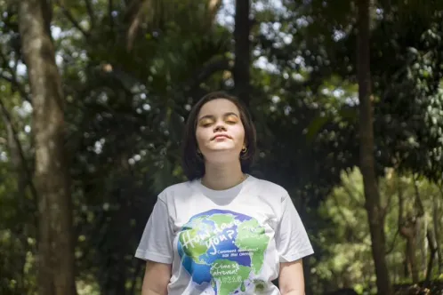 16-year-old Kyara stands in the forest in Costa Rica with her eyes closed, breathing in the natural surroundings.