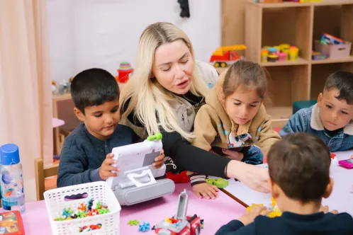 A UNICEF worker plays with children at a UNICEF-supported child-friendly space in Türkiye.