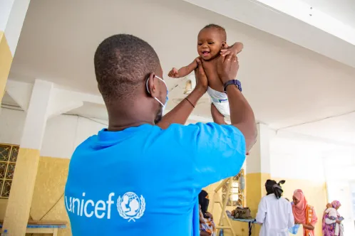 a baby held by a UNICEF representative