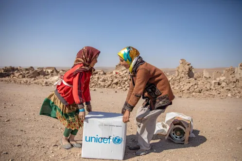 Two girls collect a family hygiene kit provided by UNICEF in Ghar Moshak District, Herat Province, western Afghanistan.