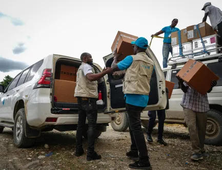 UNICEF staff loads boxes of medical kits to a UNICEF vehicle in Haiti.