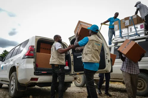 UNICEF staff loads boxes of medical kits to a UNICEF vehicle in Haiti.