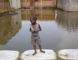 A child stands in the floodwaters in Gatumba, Burundi. 