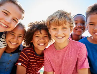 Des enfants de divers horizons sourient à la caméra.