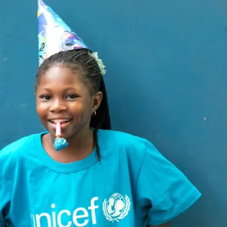 Yasmine, who is 8-years old, is photographed wearing a UNICEF t-shirt and party hat, as she celebrates-World Children’s Day in Abidjan, Côte d'Ivoire.
