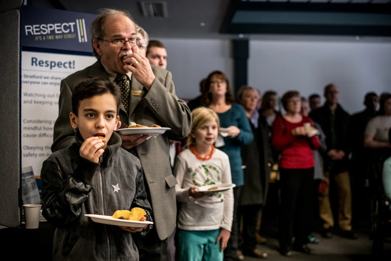 Basel (foreground) and other participants sample some of the different foods offered at the community event. 