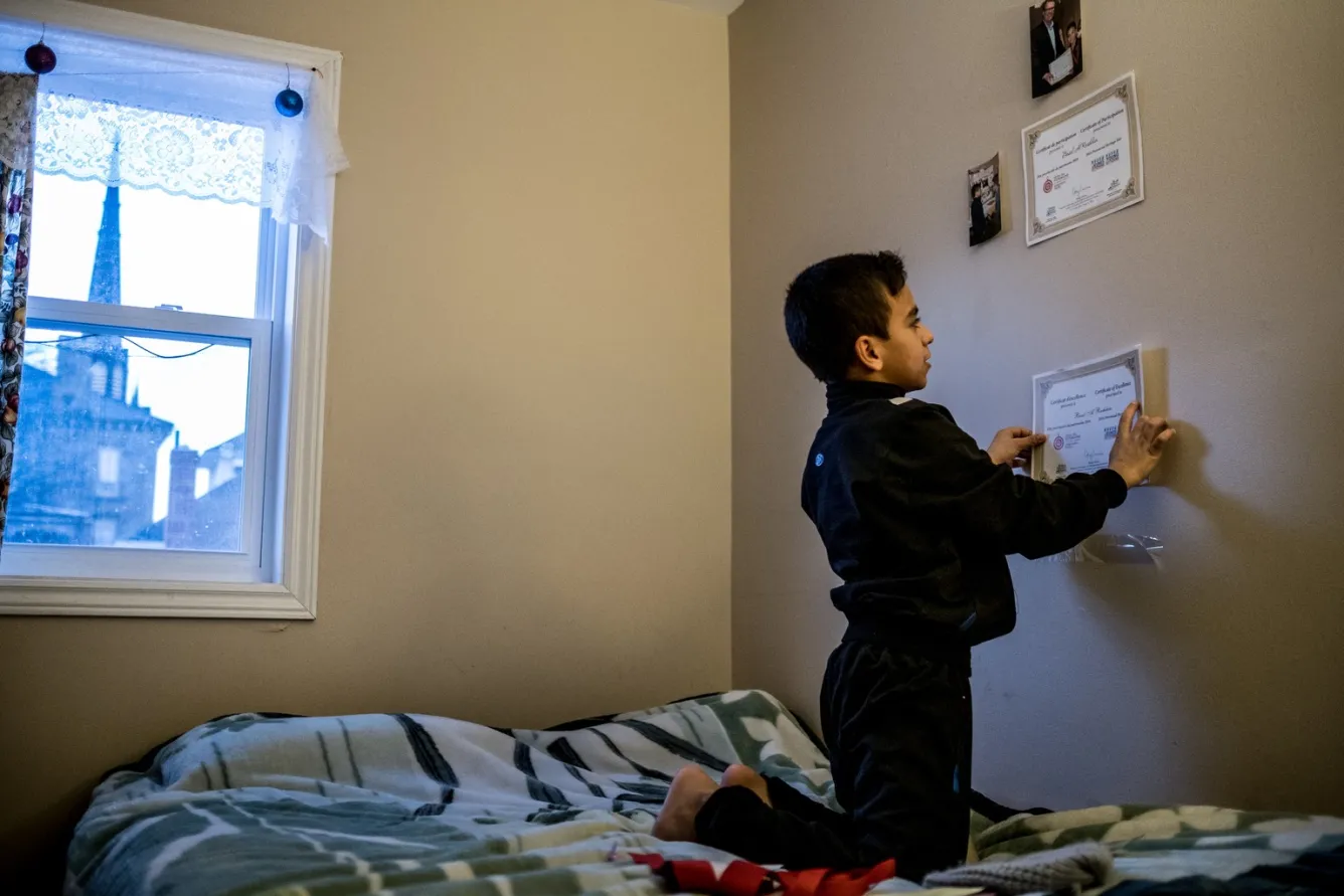Basel tapes another achievement certificate to his bedroom wall.
