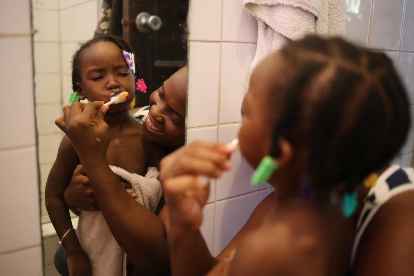 Keisha Gentle — teaching her daughter, 3-year-old Alishia, how to brush her teeth .