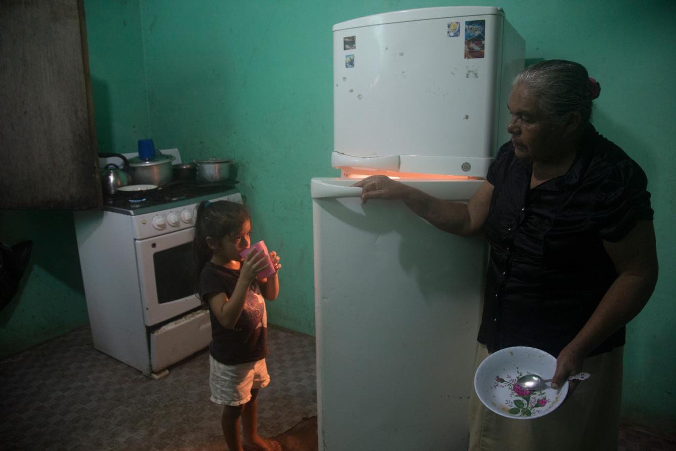 Allizon, with her great-grandmother, drinks a beverage at home.