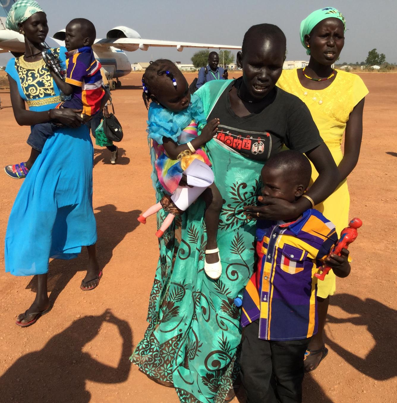A mother (centre) is overcome with emotion after being reunited with her three children after a two-year separation. UNICEF facilitated the tracing and reunion at the Rubkona air strip in northern S. Sudan.