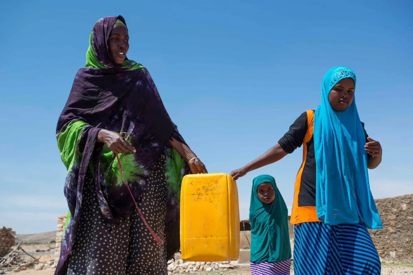 Meymun Suleiman, a resident of Rabaable village, fetches water with the help of her daughters.