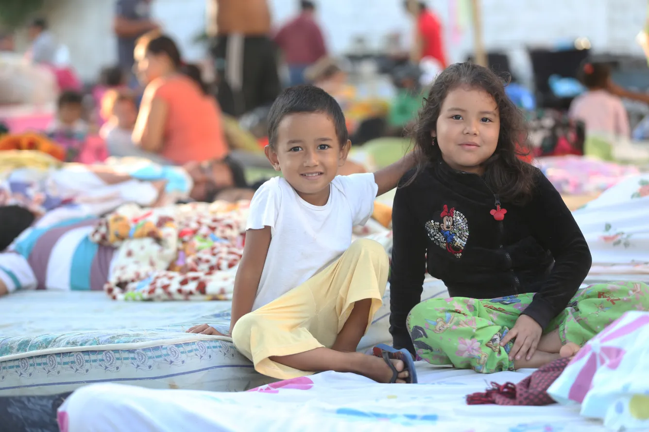 Children sit in a shelter in Ecuador.