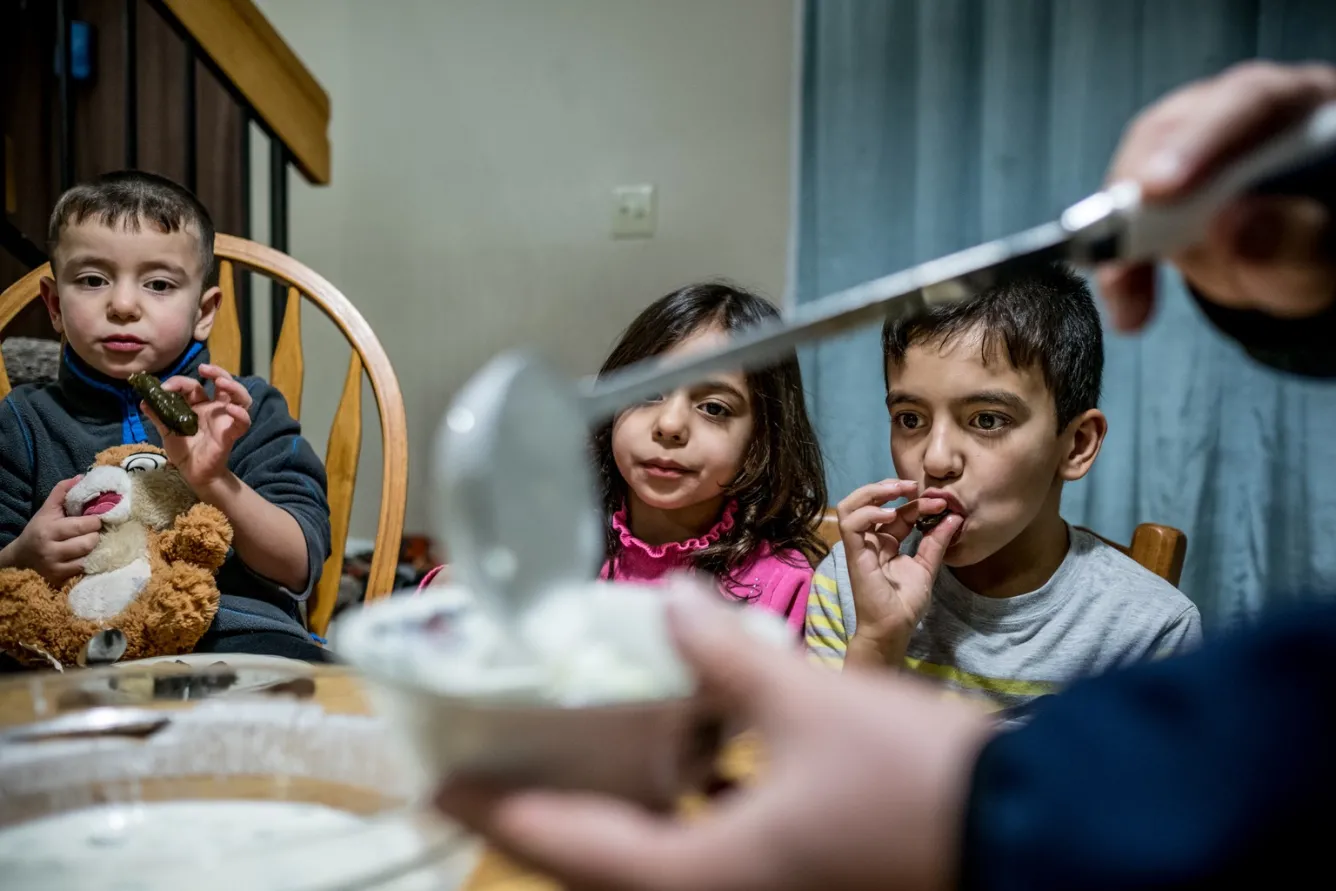 The family sits down to a traditional Middle-Eastern meal in their home.