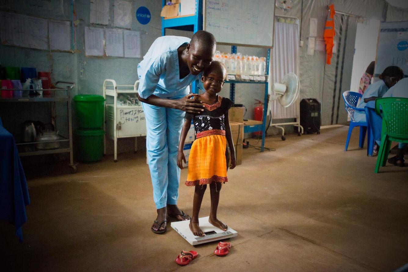 Nyajime is weighed with the help of her father