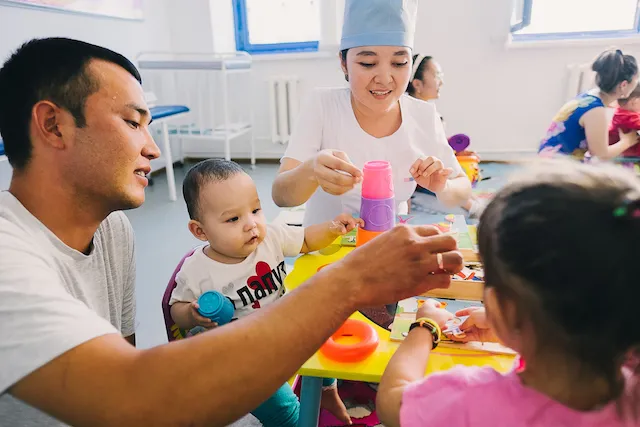A father plays with his kids at a UNICEF early childhood development program at a polyclinic in Kyzylorda, Kazakhstan. Credit: © UNICEF/UN045591/Kim