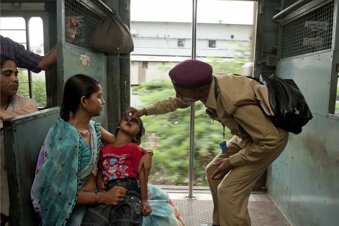 Four-year-old Aush is vaccinated against polio on a moving train in Delhi