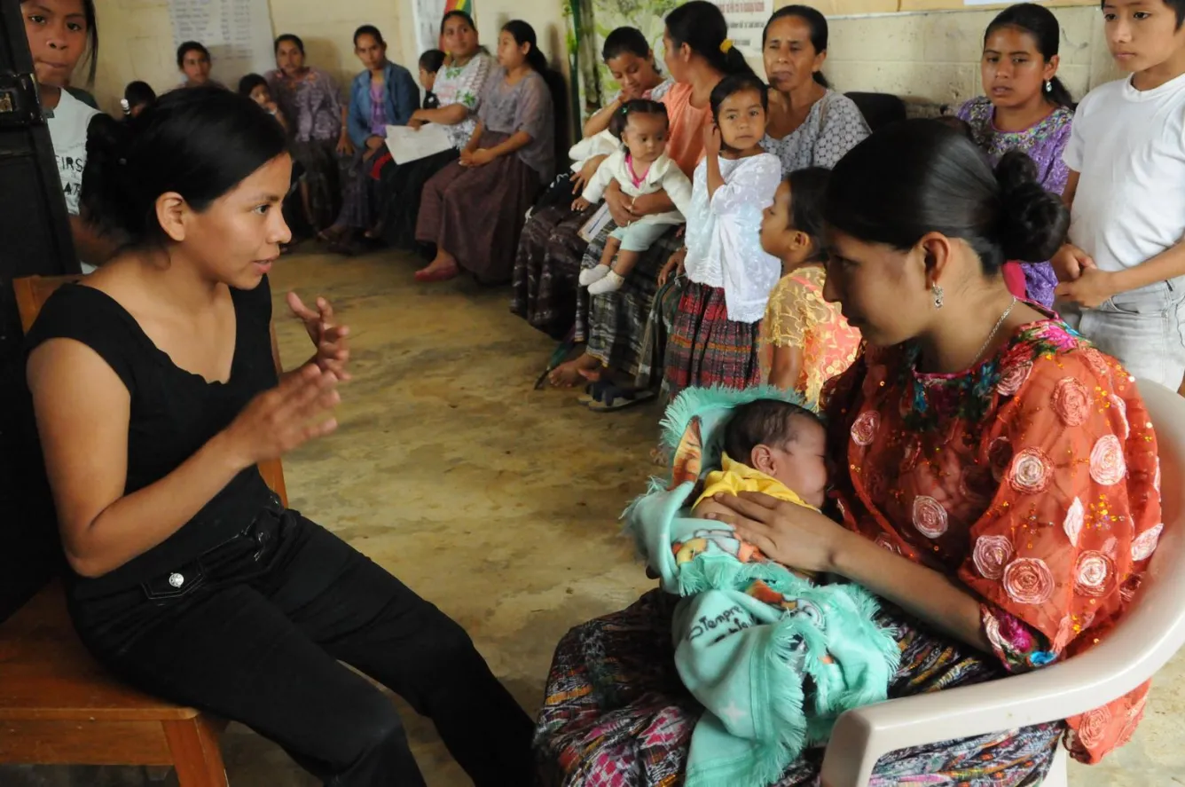 A health worker consulting with a new mother in Guatemala.