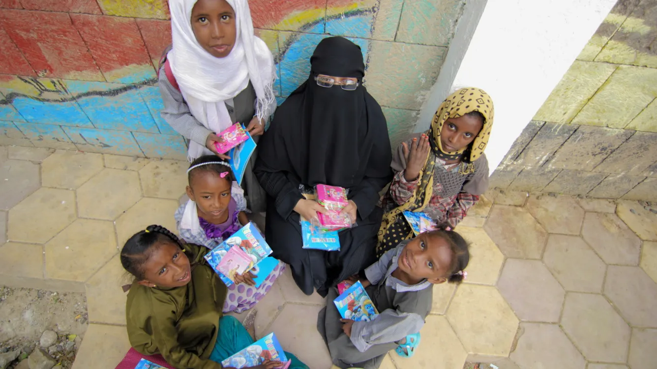 Tahani sits with some of her students.