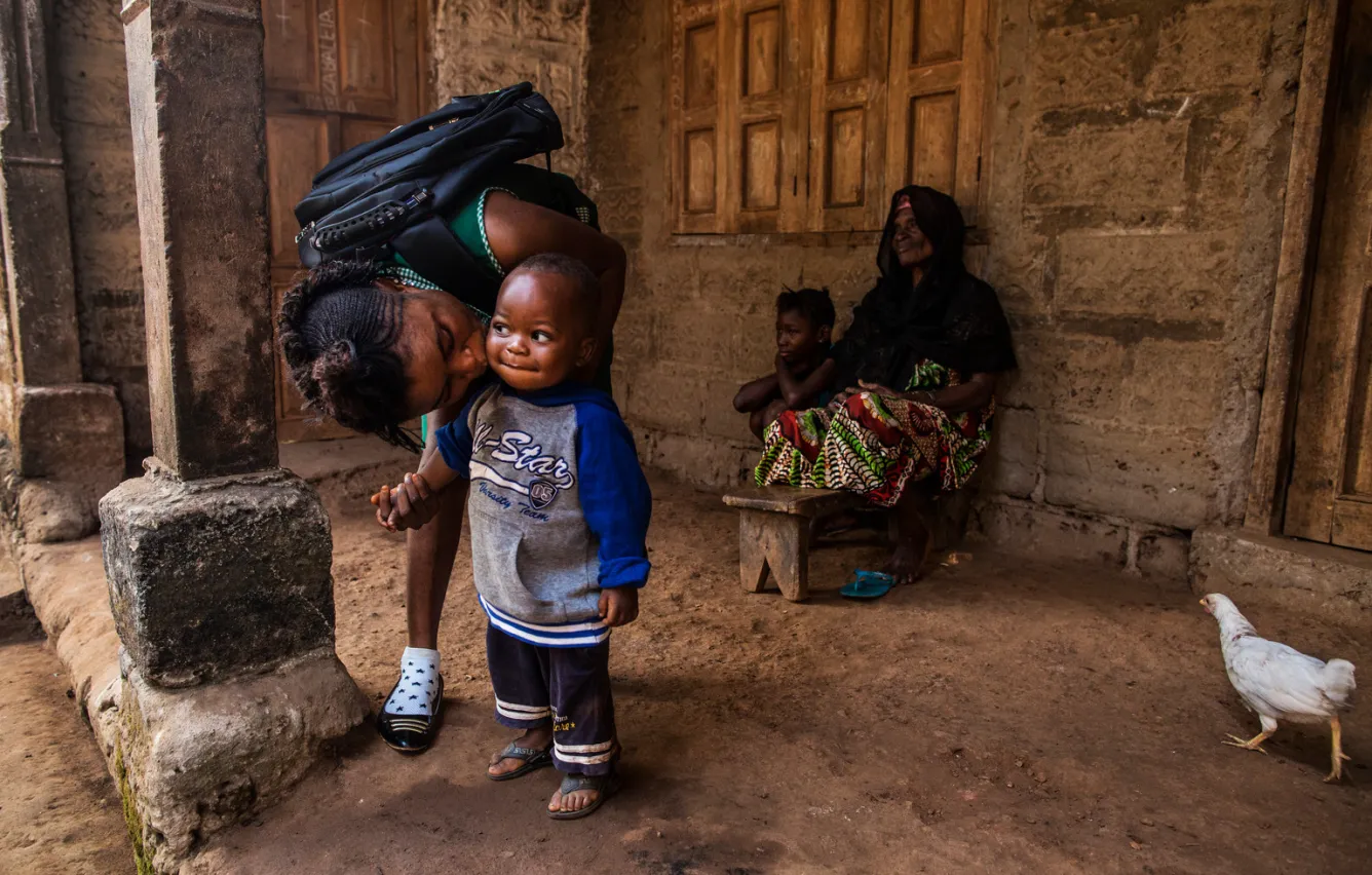 a mother kisses her son before leaving for school