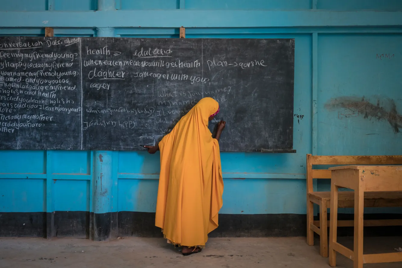a girl writes on a chalkboard in Somalia