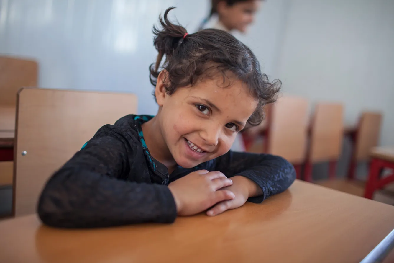 a girl sits at her desk at school