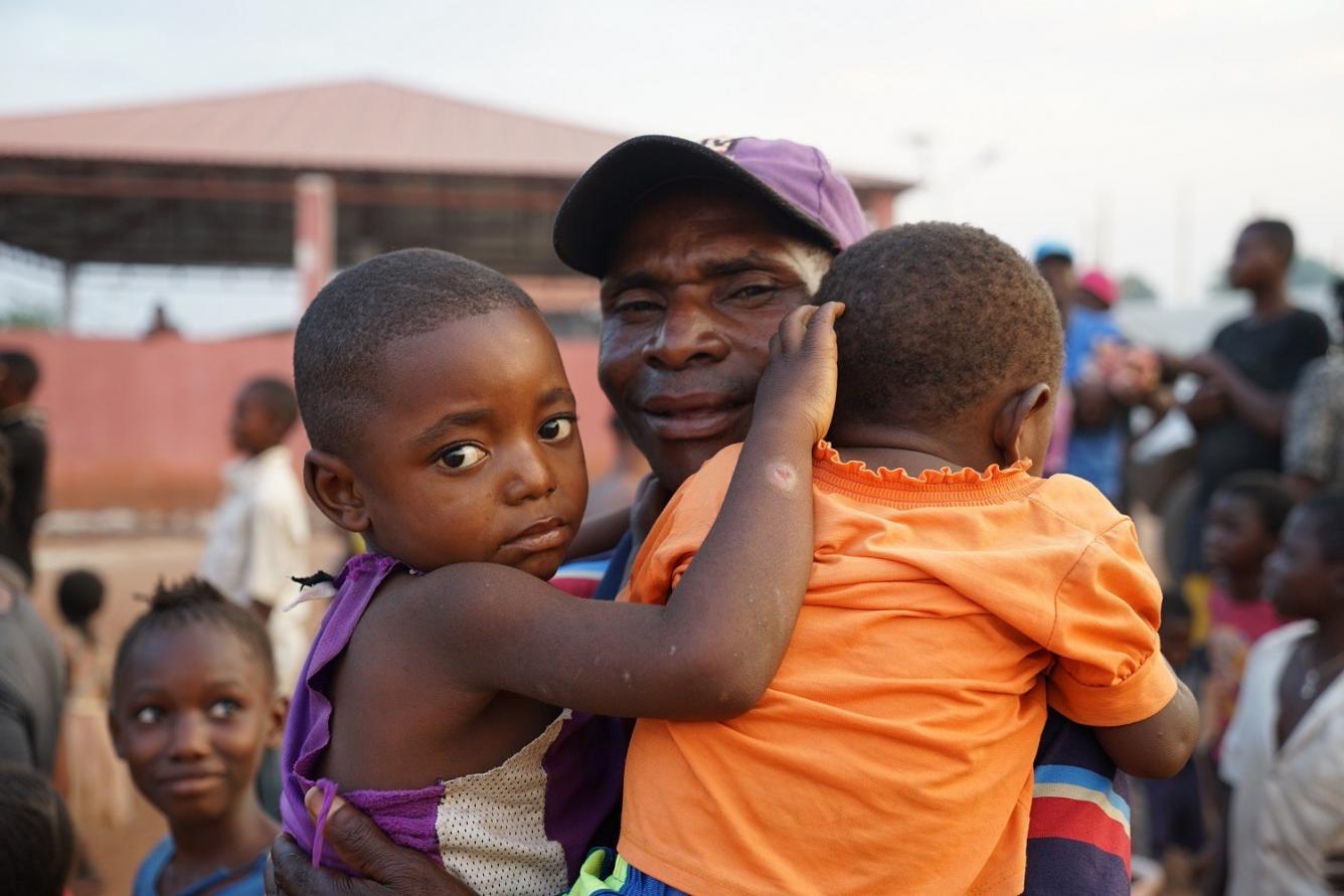 Un père sourit avec ses enfants à Dundo, Angola.