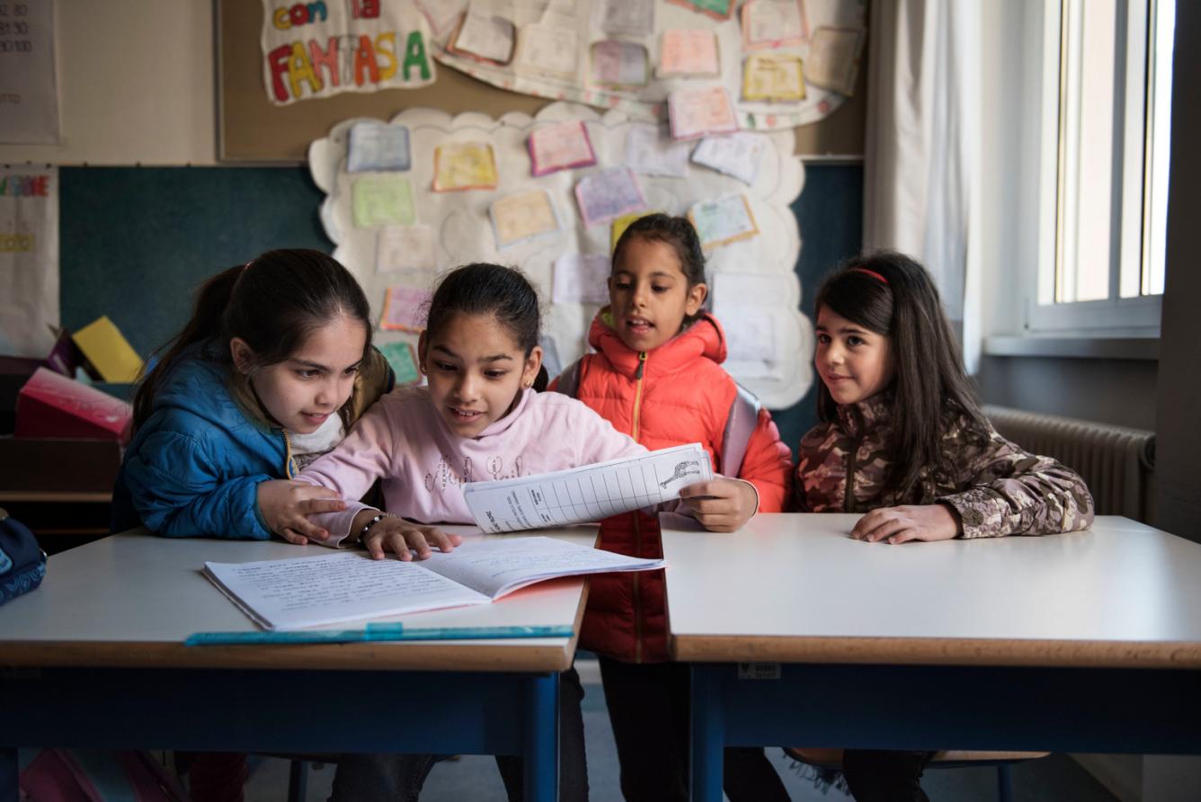Badiaa est assise à un pupitre de sa classe en compagnie de ses amies