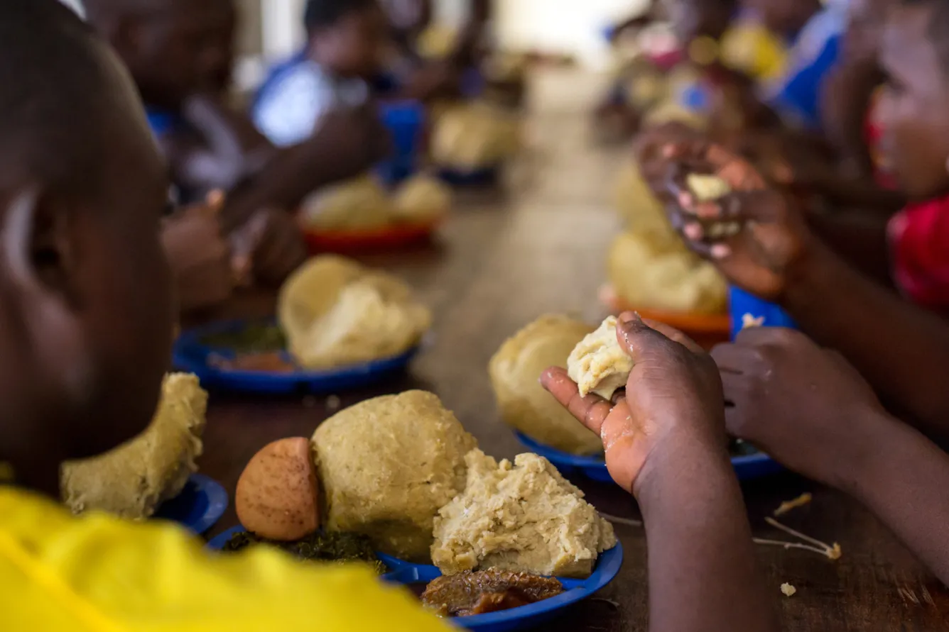Children share food at a transit and orientation centre
