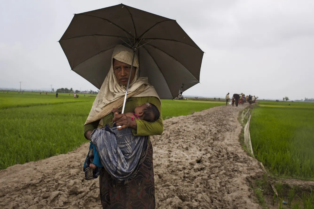 a mother and child walk to safety in Bangladesh